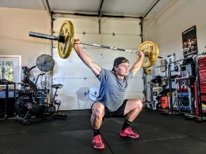 man lifting yellow barbell